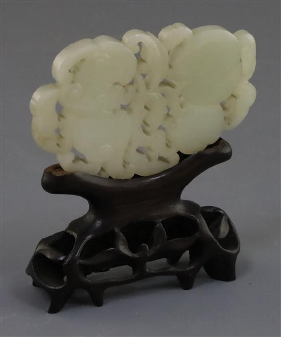 A Chinese pale celadon jade plaque, 19th century, 8.4cm, wood stand